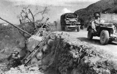 French forces advance through the mountains pass a knocked out Marder III H. French forces advance through the mountains pass a knocked out Marder III H.